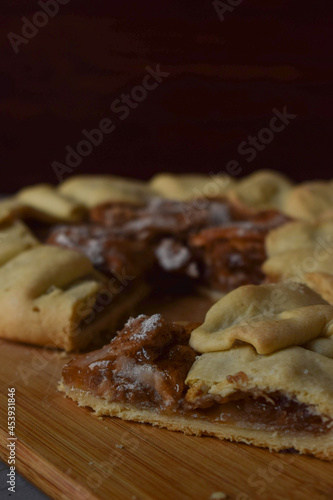 galette or an open pie with apples and cinnamon on a wooden board