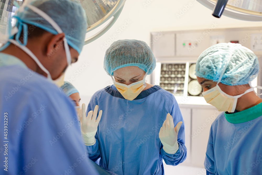 Surgeons bent over patient on operating table Surgeons bent over patient on operating table