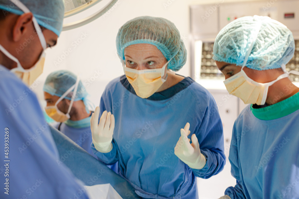 Surgeons bent over patient on operating table Surgeons bent over patient on operating table