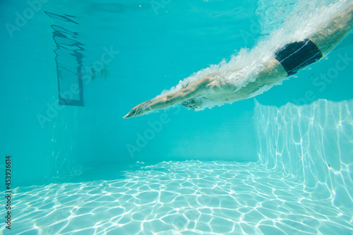 Man swimming underwater in pool © KOTO