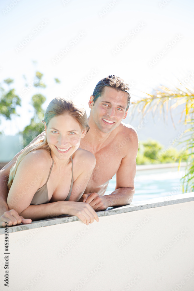 Portrait of smiling couple relaxing in swimming pool