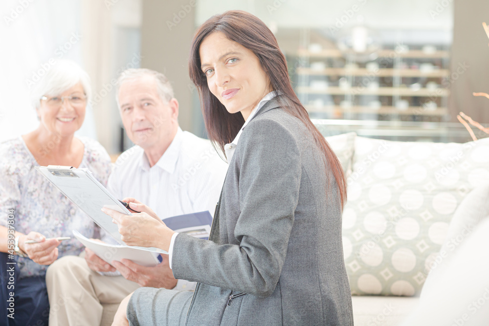 Fototapeta premium Financial advisor smiling with couple on sofa