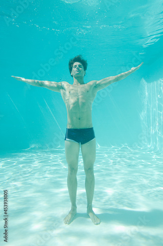 Man posing underwater in swimming pool