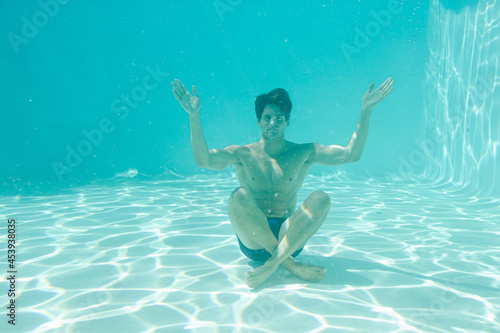 Man posing underwater in swimming pool