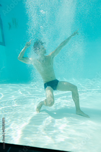 Man posing underwater in swimming pool