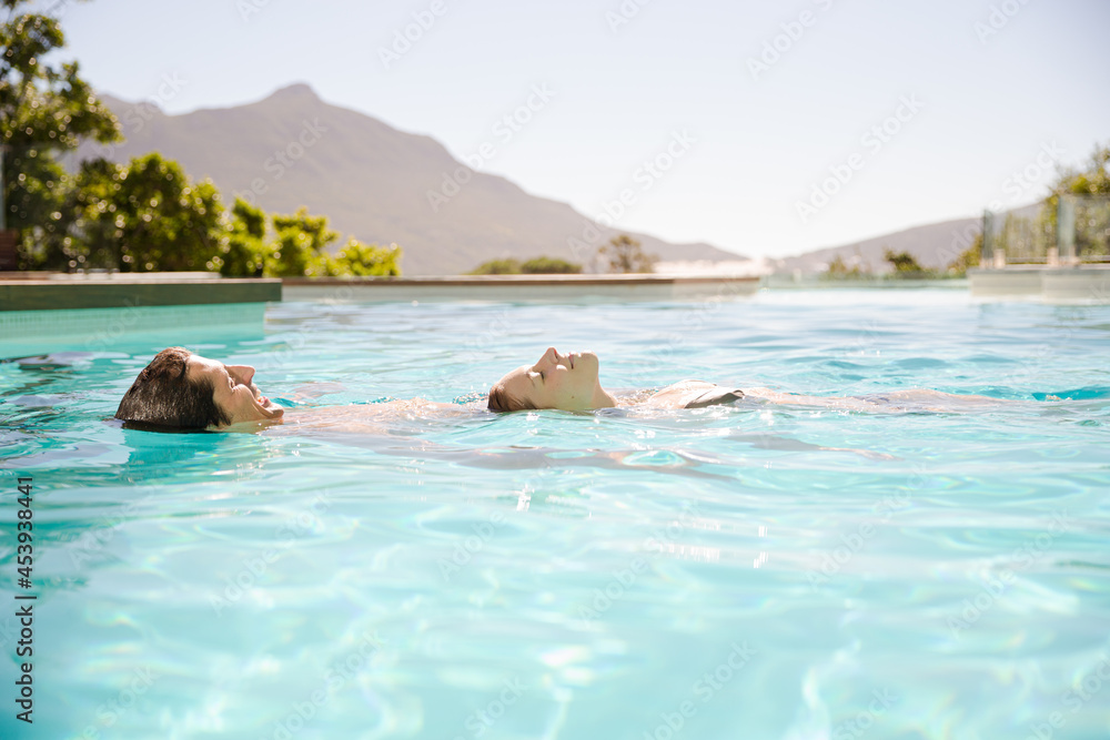 Fototapeta premium Couple floating in swimming pool