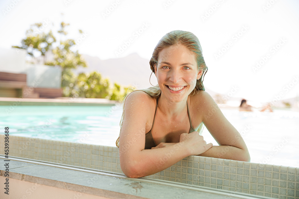 Portrait of smiling woman at the edge of swimming pool