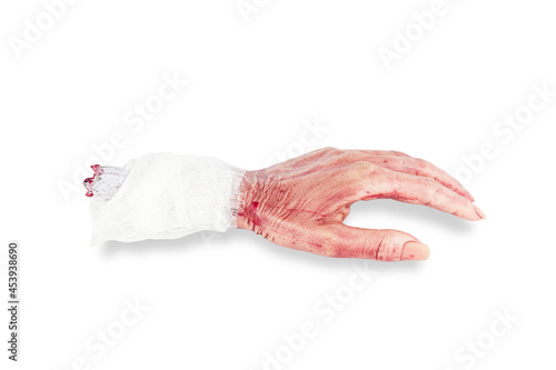 Realistic artificial cutted off bloody dead human hand with bandage, isolated on white background photo