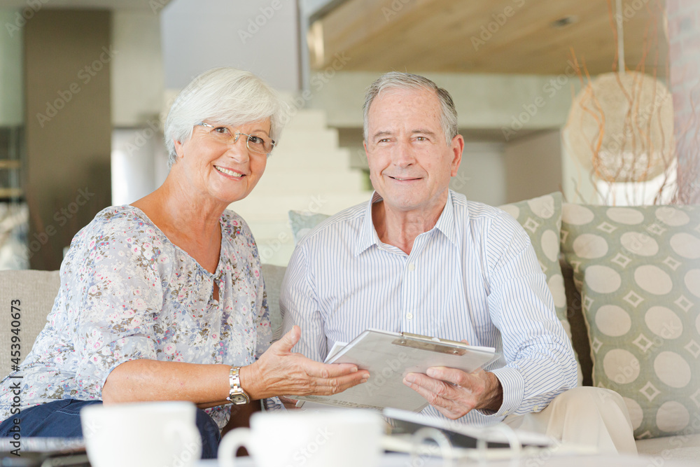 Couple examining blueprints on sofa Couple examining blueprints on sofa