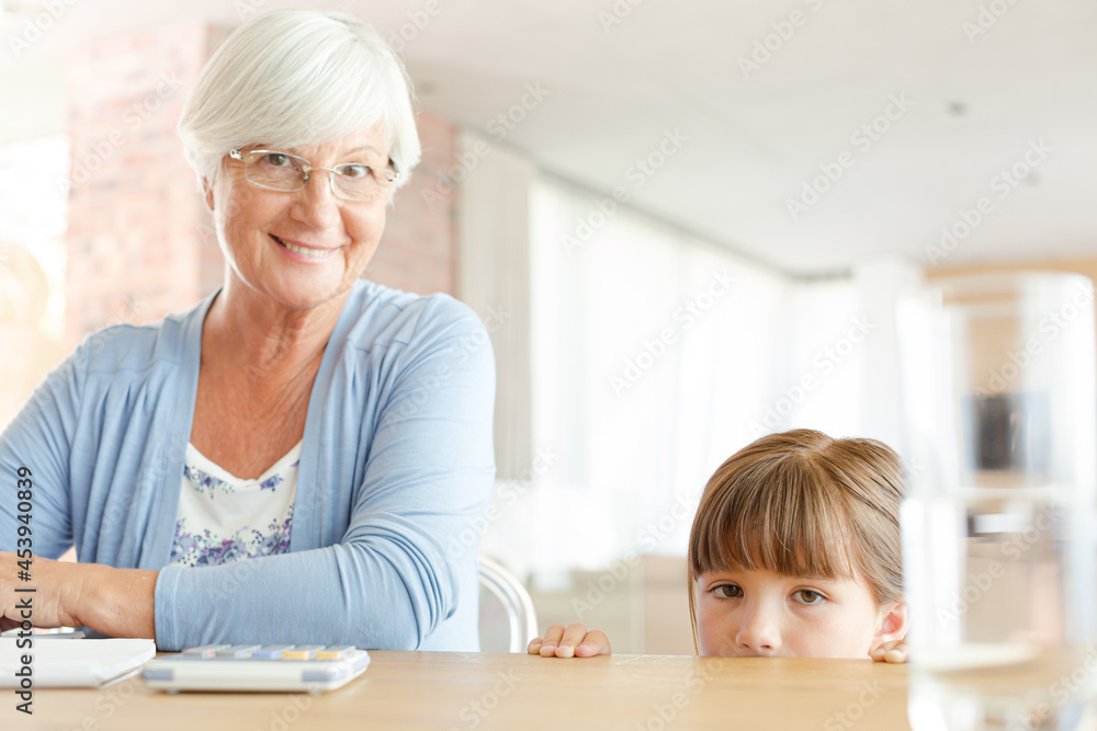 Older woman and granddaughter using calculator Older woman and granddaughter using calculator
