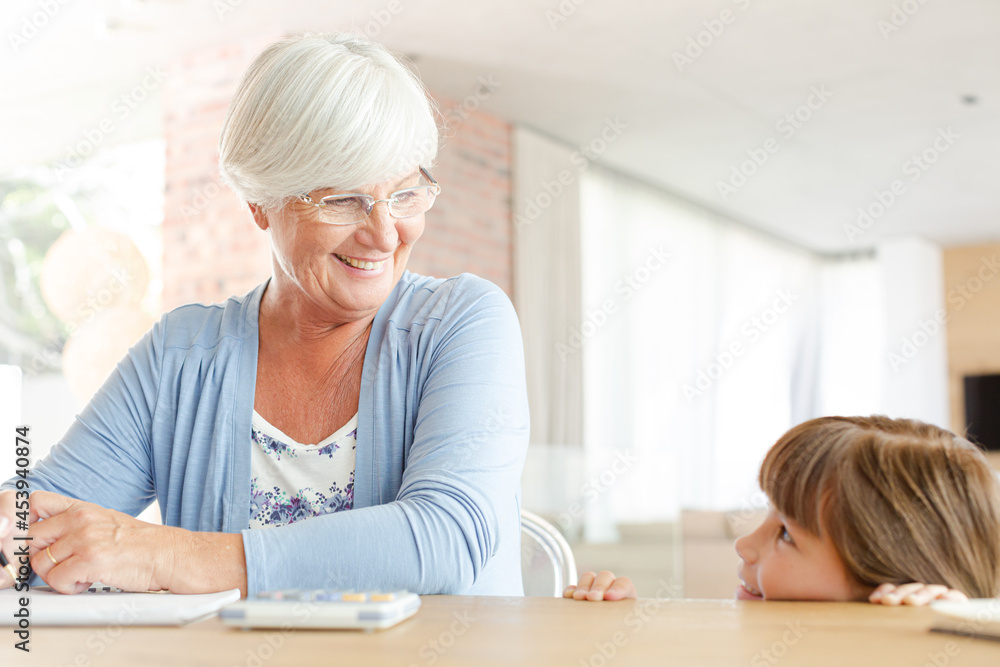 Older woman and granddaughter using calculator Older woman and granddaughter using calculator