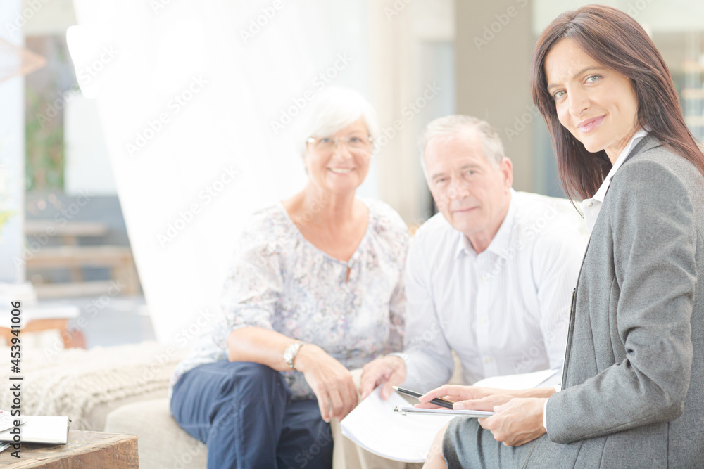 Financial advisor smiling with couple on sofa Financial advisor smiling with couple on sofa
