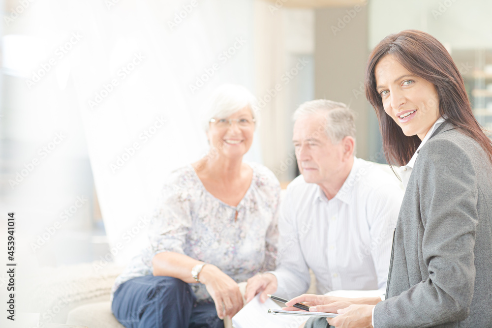 Financial advisor smiling with couple on sofa Financial advisor smiling with couple on sofa