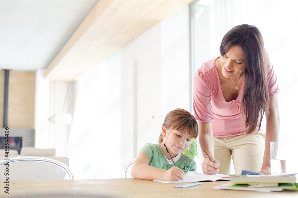 Mother helping daughter with homework Mother helping daughter with homework