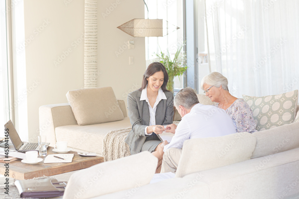 Financial advisor talking to couple on sofa Financial advisor talking to couple on sofa