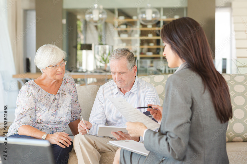 Financial advisor talking to couple on sofa Financial advisor talking to couple on sofa