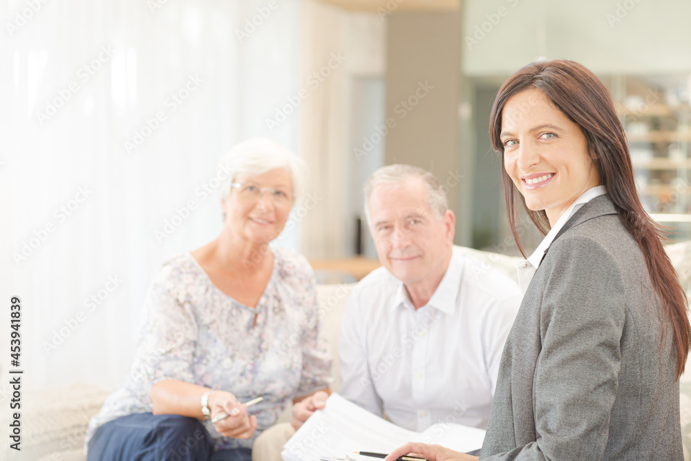 Financial advisor smiling with couple on sofa Financial advisor smiling with couple on sofa