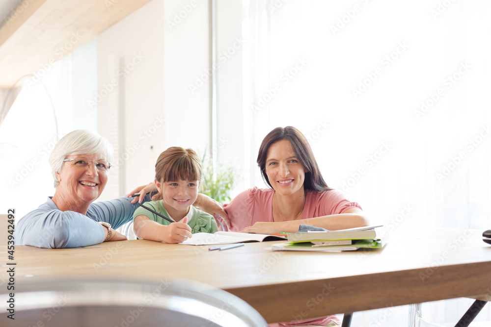 Mother and grandmother helping girl with homework Mother and grandmother helping girl with homework