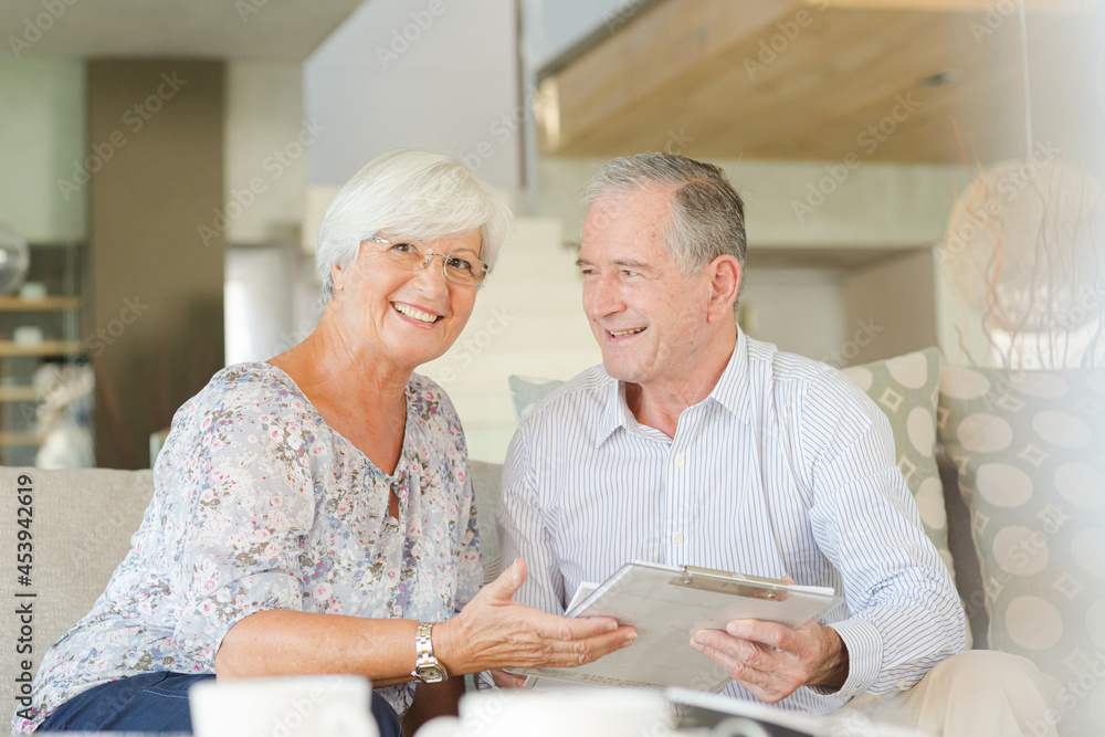 Couple examining blueprints on sofa Couple examining blueprints on sofa