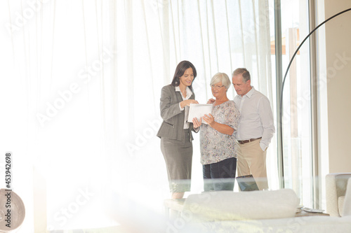 Financial advisor talking to couple indoors © KOTO