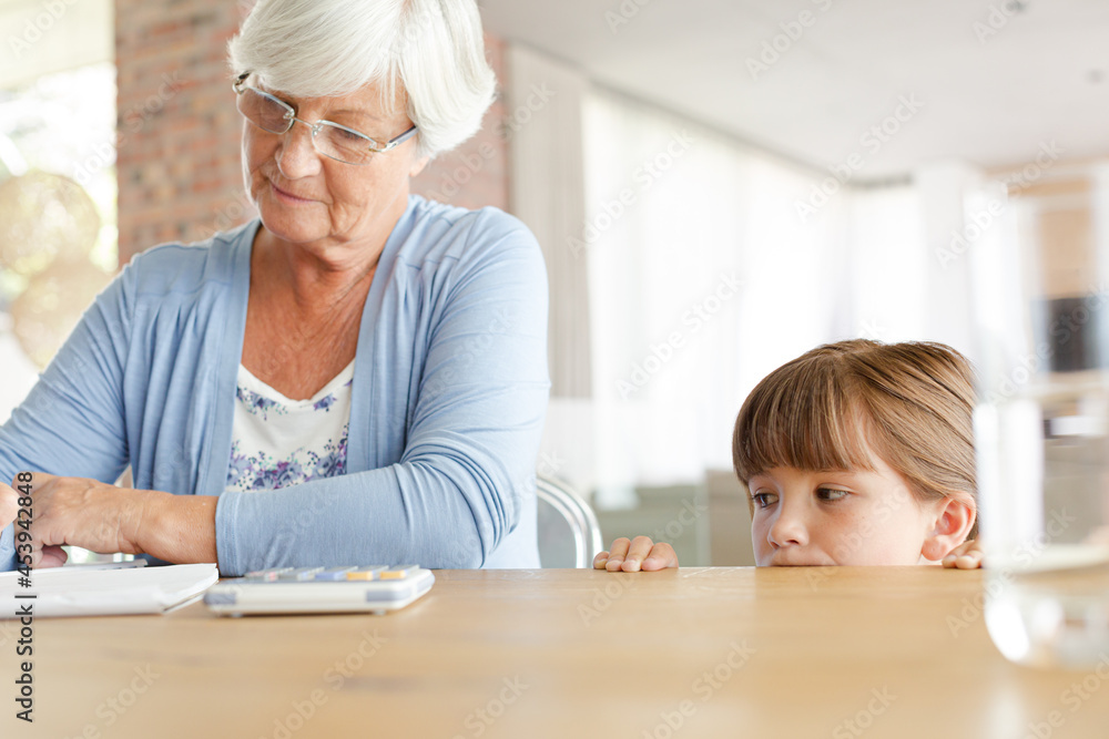 Older woman and granddaughter using calculator Older woman and granddaughter using calculator
