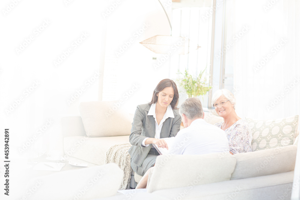 Financial advisor talking to couple on sofa Financial advisor talking to couple on sofa