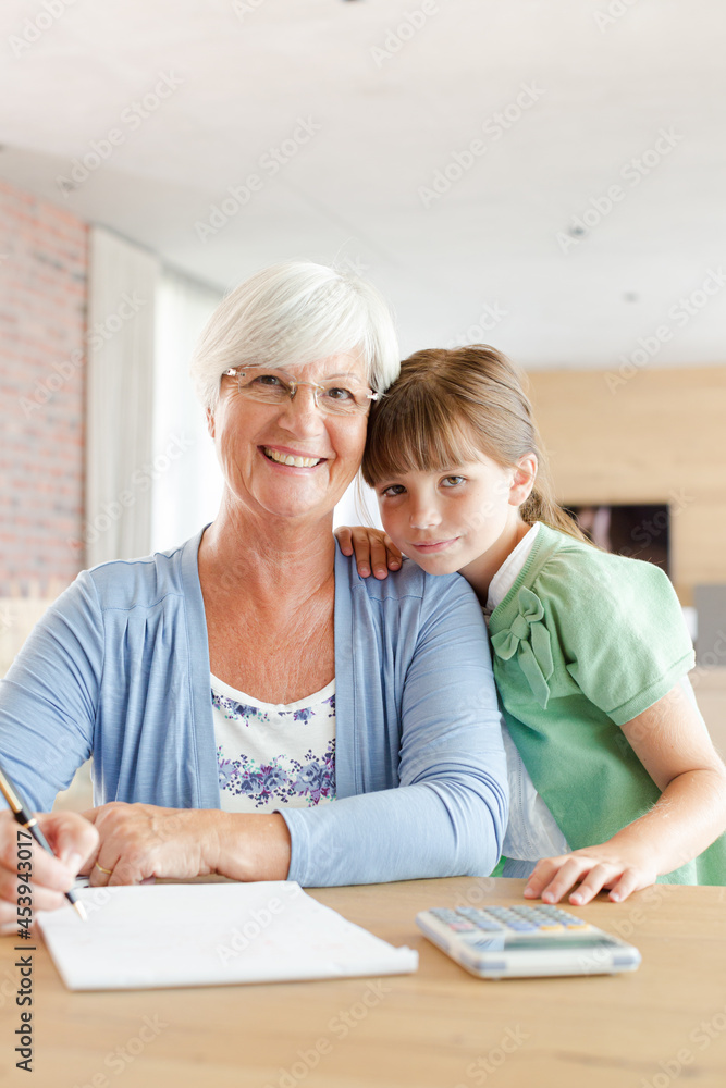 Older woman and granddaughter using calculator Older woman and granddaughter using calculator
