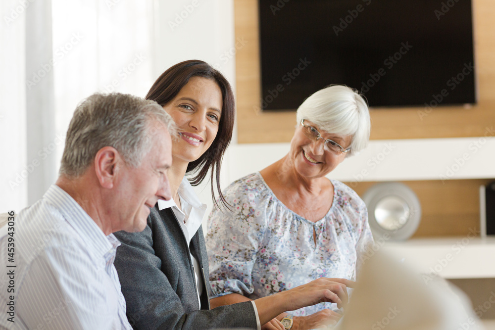 Financial advisor sitting on sofa with clients Financial advisor sitting on sofa with clients