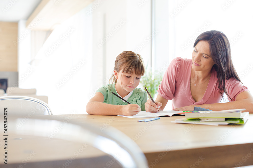 Mother helping daughter with homework Mother helping daughter with homework