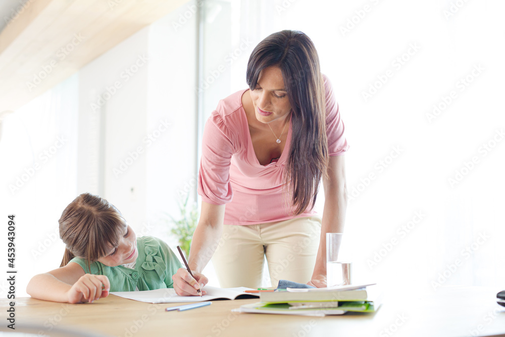 Mother helping daughter with homework Mother helping daughter with homework