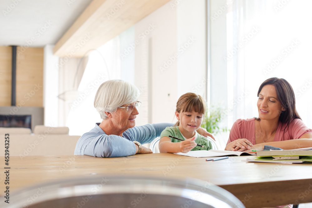 Mother and grandmother helping girl with homework Mother and grandmother helping girl with homework