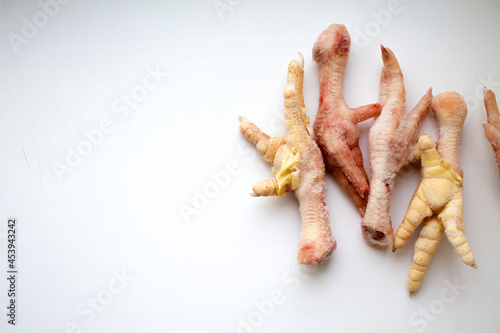frozen chicken legs on a white background. food for broth. delicacy for dogs.