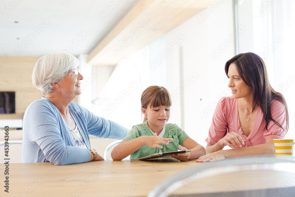 Three generations of women using tablet computer