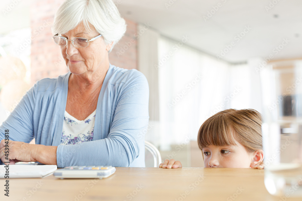 Older woman and granddaughter using calculator Older woman and granddaughter using calculator