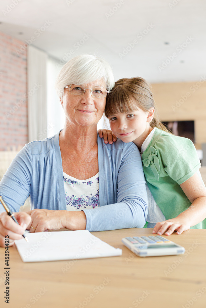Older woman and granddaughter using calculator Older woman and granddaughter using calculator