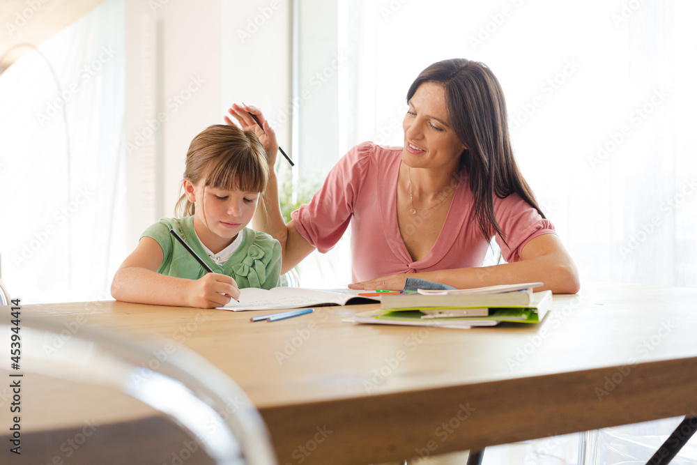 Mother helping daughter with homework Mother helping daughter with homework