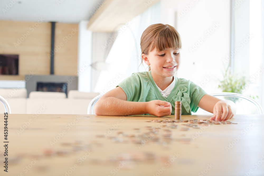 Girl stacking pennies on counter Girl stacking pennies on counter