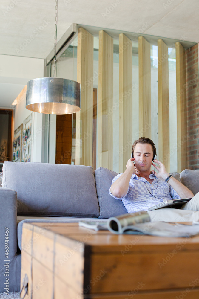 Man using headphones on sofa Man using headphones on sofa