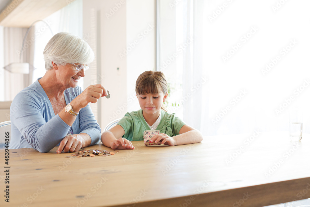 Older woman and granddaughter counting pennies Older woman and granddaughter counting pennies