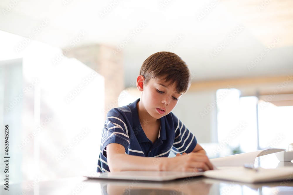 Boy using tablet computer in kitchen Boy using tablet computer in kitchen