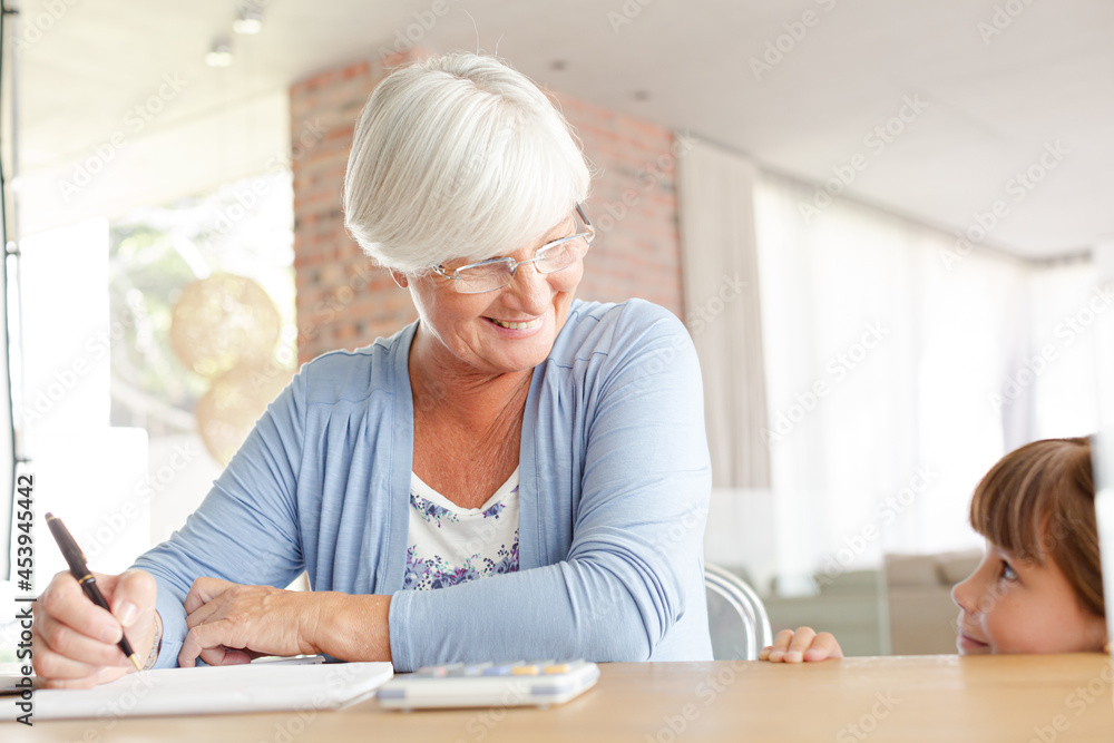 Older woman and granddaughter using calculator Older woman and granddaughter using calculator