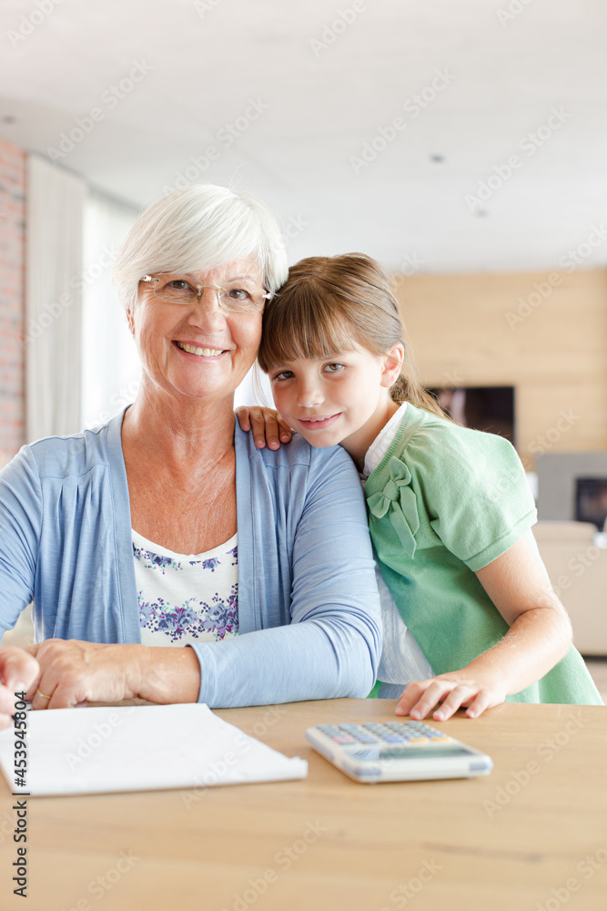 Older woman and granddaughter using calculator Older woman and granddaughter using calculator