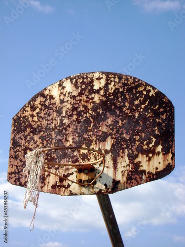 rusted basketball hoop against the sky