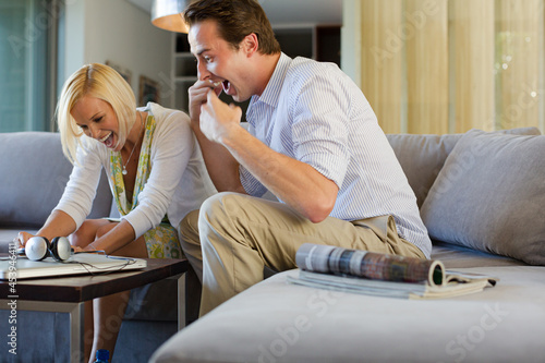 Couple checking lottery tickets on sofa