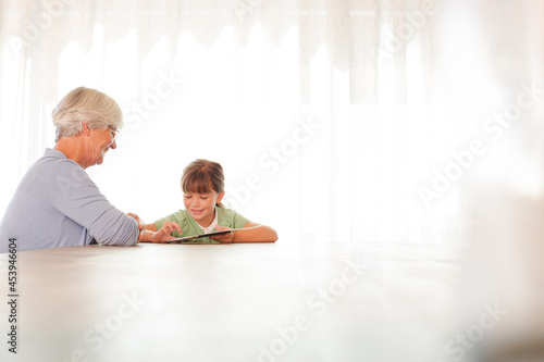 Older woman and granddaughter using tablet computer