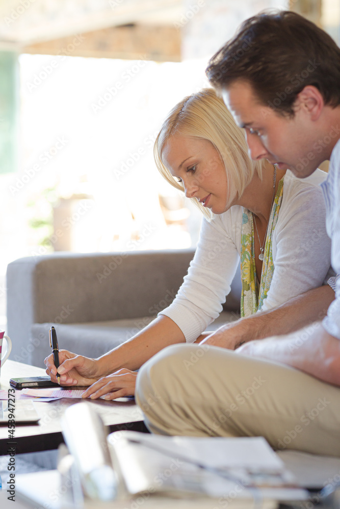 Couple checking lottery tickets on sofa Couple checking lottery tickets on sofa