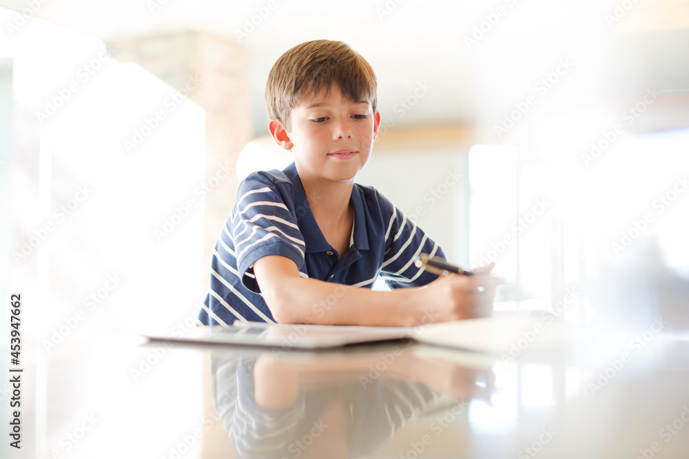 Boy using tablet computer in kitchen Boy using tablet computer in kitchen