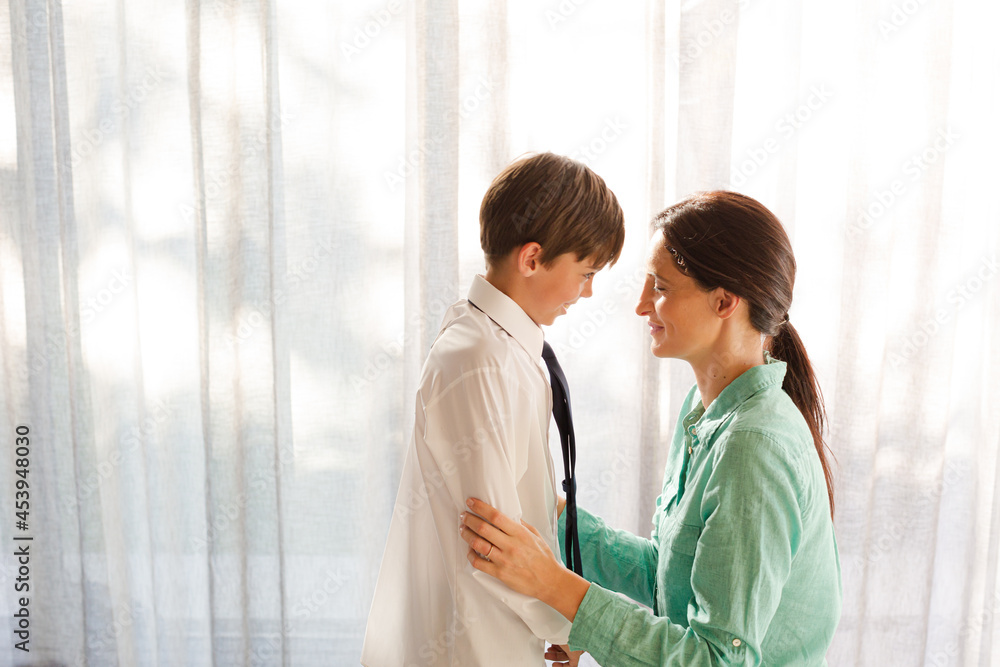 Fototapeta premium Mother and son touching foreheads at window