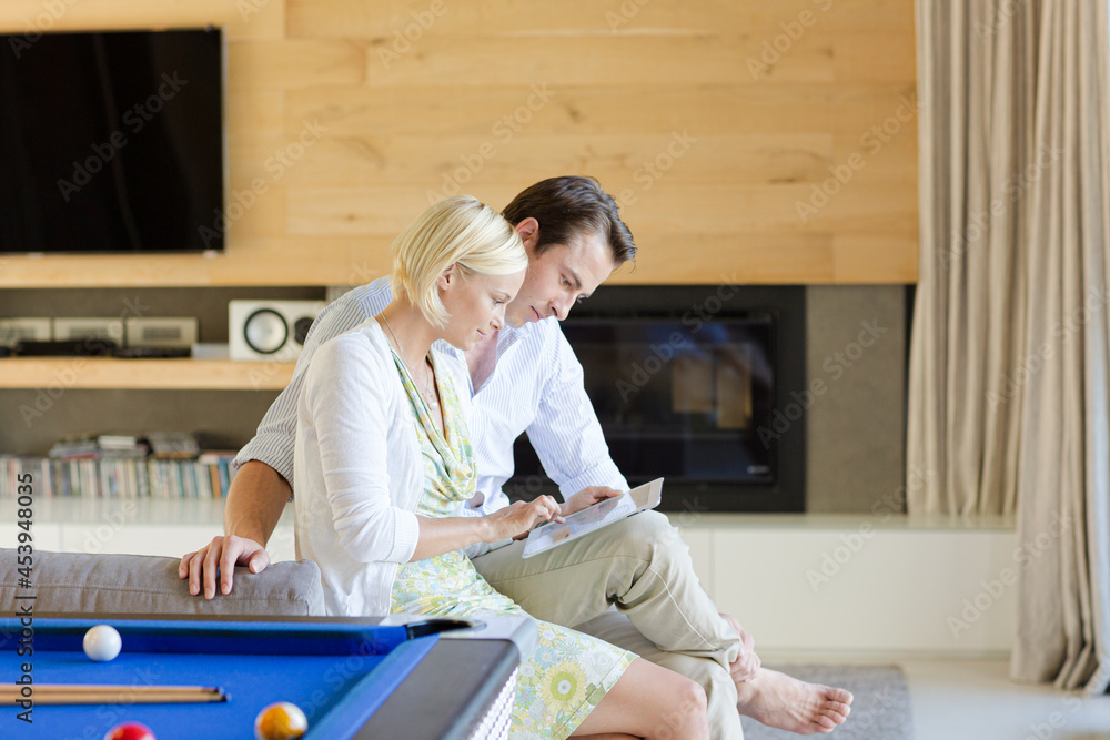 Obraz premium Couple using tablet computer on sofa