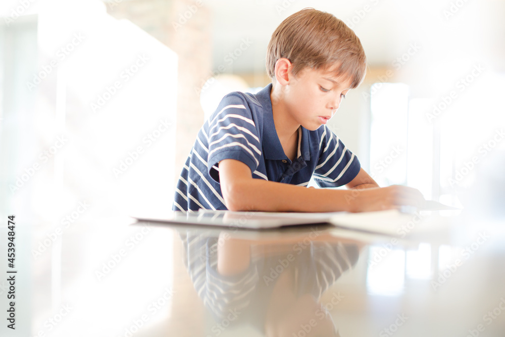 Boy using tablet computer in kitchen Boy using tablet computer in kitchen